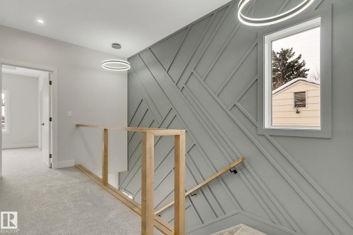 Architectural wall feature with geometric paneling, light wood handrail, and carpeted flooring - 11132 72 Avenue, Edmonton, AB - Indoor Photo Showing Other Room