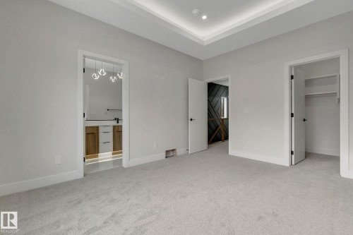 Spacious room featuring light gray carpeting and walls, a tray ceiling with recessed lighting, and white baseboards - 11132 72 Avenue, Edmonton, AB - Indoor Photo Showing Other Room