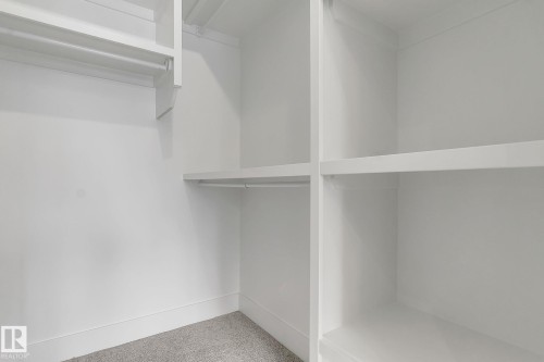 Custom closet system featuring white shelving and hanging rods - 11132 72 Avenue, Edmonton, AB - Indoor With Storage