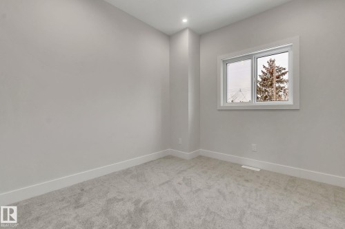Neutral-toned wall finishes with a single window featuring white trim - 11132 72 Avenue, Edmonton, AB - Indoor Photo Showing Other Room