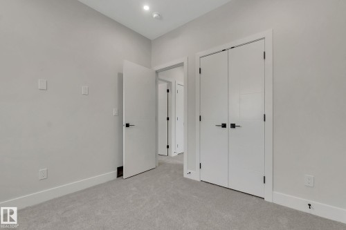 Neutral color palette featuring light grey walls, white trim, and light grey carpeting - 11132 72 Avenue, Edmonton, AB - Indoor Photo Showing Other Room