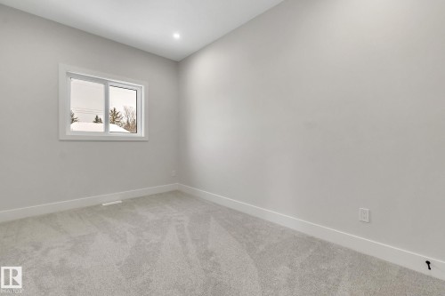 Neutral-toned room featuring a single window with white trim, light gray carpet flooring, recessed ceiling lighting, and white baseboards - 11132 72 Avenue, Edmonton, AB - Indoor Photo Showing Other Room