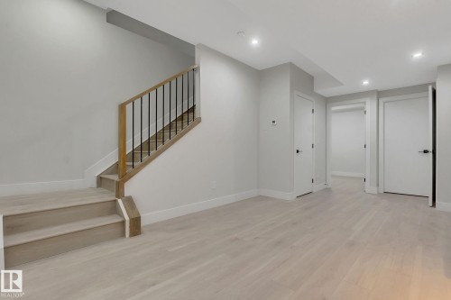 Light wood-finish flooring extending from the main area to the staircase - 11132 72 Avenue, Edmonton, AB - Indoor Photo Showing Other Room