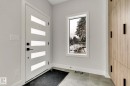 Entryway featuring a contemporary white door with frosted glass inserts, a single pane vertical window, and wood-look cabinetry with black hardware - 11132 72 Avenue, Edmonton, AB  - Indoor Photo Showing Other Room 
