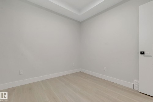 Light wood-finish flooring, white baseboards, and neutral wall tones create a bright interior space - 11132 72 Avenue, Edmonton, AB - Indoor Photo Showing Other Room