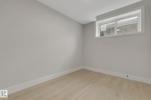 Light-toned wood-finish flooring complements neutral wall tones - 11132 72 Avenue, Edmonton, AB - Indoor Photo Showing Other Room