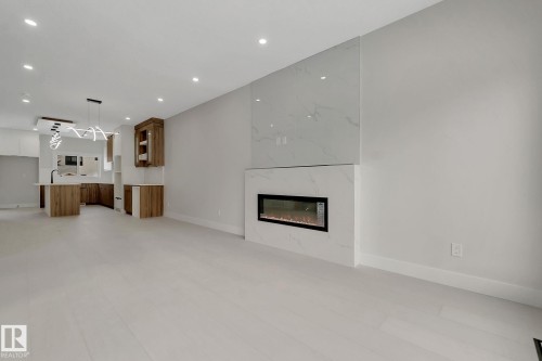Integrated electric fireplace with a floor-to-ceiling tile surround - 11132 72 Avenue, Edmonton, AB - Indoor With Fireplace