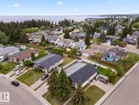 Residential neighborhood featuring mature trees, paved streets, and a prominent water body in the background - 210 22 Street, Cold Lake, AB 