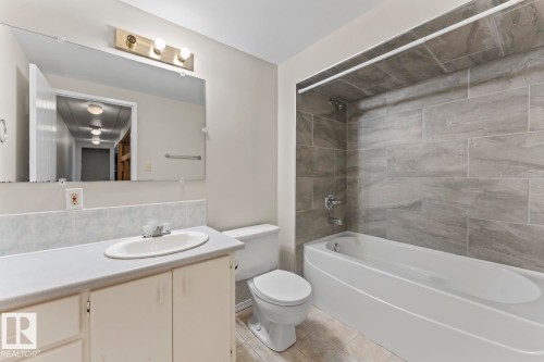 Bathroom featuring a white vanity with integrated sink, chrome faucet, and a large wall-mounted mirror - 210 22 Street, Cold Lake, AB 