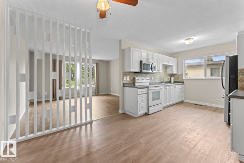 Bright kitchen with wood-finish flooring and white cabinetry - 210 22 Street, Cold Lake, AB 