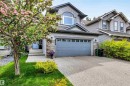 Two-story residence featuring grey siding, stone accents, and an integrated two-car garage - 11935 21 Avenue, Edmonton, AB 