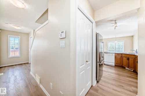 Entryway featuring wood-finish flooring, a staircase, and a window - 3711 22A St, Edmonton, AB 