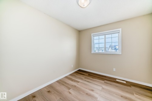 Neutral-toned walls complement wood-finish flooring in this room - 3711 22A St, Edmonton, AB 