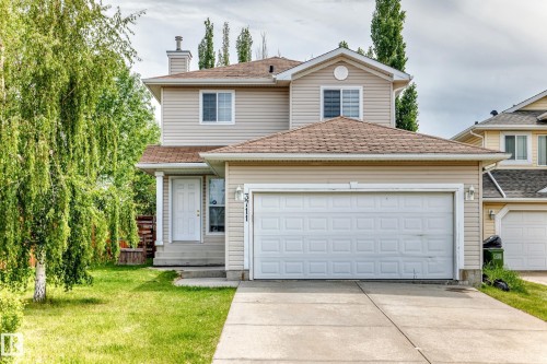 Two-story residence featuring light-toned siding and a brown shingled roof - 3711 22A St, Edmonton, AB 