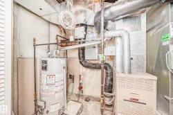 Utility area featuring a water heater and a Lennox furnace unit - 
