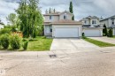 Two-story residence featuring light-colored siding, a brown shingle roof, and a two-car attached garage - 3711 22A St, Edmonton, AB 