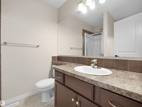 Bathroom featuring a vanity with a white oval sink, chrome faucet, and dark brown cabinetry - 21316 45A Avenue Nw, Edmonton, AB 
