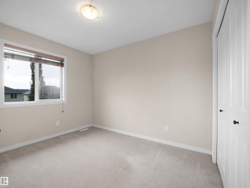 Neutral-toned carpeting, white baseboards, and a window with blinds - 21316 45A Avenue Nw, Edmonton, AB 
