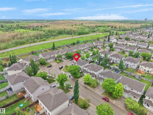 Aerial perspective of a developed residential neighborhood featuring detached homes with fenced backyards and mature trees - 21316 45A Avenue Nw, Edmonton, AB 