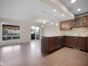 Kitchen featuring wood-finish cabinetry, light-toned countertops, and a subway tile backsplash - 21316 45A Avenue Nw, Edmonton, AB 