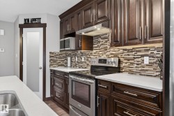 Kitchen featuring dark wood-finish cabinetry, light-toned countertops, and a full tile backsplash - 