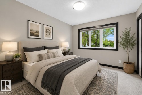 Carpeted room with a large window featuring black trim, a flat ceiling, and a flush-mount ceiling light fixture - 8506 80 Avenue, Edmonton, AB 