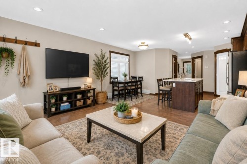 Open-concept living area featuring wood-finish flooring, recessed lighting, and neutral wall tones - 8506 80 Avenue, Edmonton, AB 