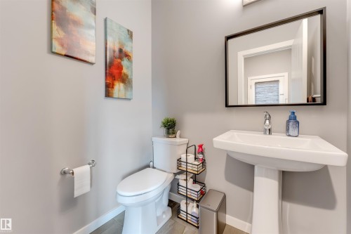 Pedestal sink with chrome faucet, framed mirror, and light gray walls - 2652 Maple Way, Edmonton, AB - Indoor Photo Showing Bathroom
