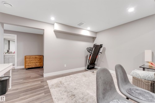 Spacious lower-level area featuring light gray walls, recessed lighting, and wood-finish flooring - 2652 Maple Way, Edmonton, AB - Indoor