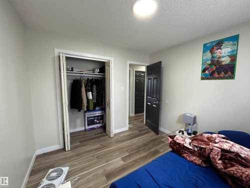 Interior room featuring wood-finish flooring, light gray wall paint, and white trim - 10924 30 Street, Edmonton, AB 