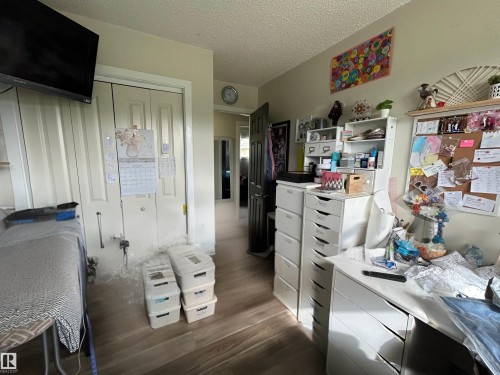 Hallway featuring wood-finish flooring, light-toned walls, and white trim - 10924 30 Street, Edmonton, AB 