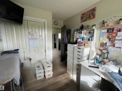 Hallway featuring wood-finish flooring, light-toned walls, and white trim - 