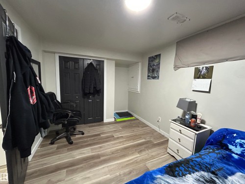 Room featuring wood-finish flooring, light gray walls, and white trim - 10924 30 Street, Edmonton, AB 