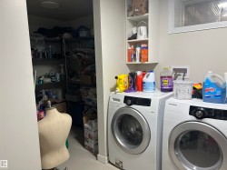 Laundry area with white walls and light-toned flooring - 
