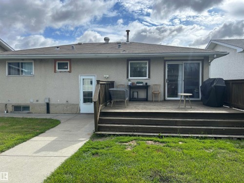 Spacious rear wood-finish deck with integrated steps, featuring a sliding glass patio door and an additional single entry door - 10924 30 Street, Edmonton, AB 