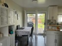 Kitchen with a tiled floor, white cabinetry, and light wood-finish countertops - 10924 30 Street, Edmonton, AB 