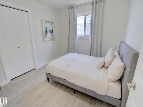 Bedroom featuring light wood-finish flooring, white walls, and a window with natural light - 9909 157 Street, Edmonton, AB 