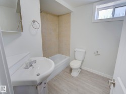 Bathroom featuring a white vanity with integrated sink, chrome faucet, and under-sink storage - 