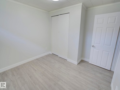 Neutral-toned room featuring light wood-finish flooring - 9909 157 Street, Edmonton, AB 
