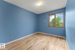 Room with light-toned wood-finish flooring, white baseboards, and a neutral ceiling - 