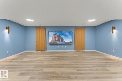 Spacious room featuring light blue walls, light wood-finish flooring, and recessed ceiling lighting - 
