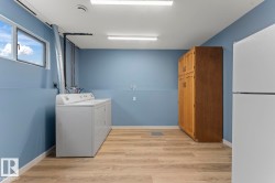 Laundry room with light wood-finish flooring, a double window, and recessed lighting - 