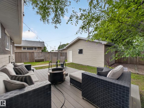 Spacious backyard featuring a composite deck, a detached shed with vinyl siding, and a wood privacy fence - 15803 83 Avenue, Edmonton, AB 