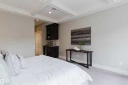 Recessed lighting illuminates a coffered ceiling, complementing the light gray wall finish - 