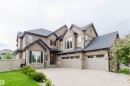 Contemporary stucco exterior with stone accents and a multi-gabled roofline - 3435 Keswick Boulevard, Edmonton, AB 
