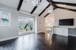 Vaulted ceiling with exposed dark wood beams and white tongue-and-groove paneling - 