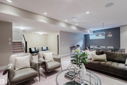 Finished lower level with recessed lighting, carpeted flooring, a dedicated dining area with a linear pendant light fixture, and an egress window - 3435 Keswick Boulevard, Edmonton, AB 