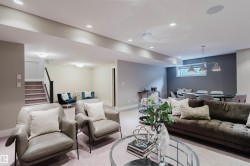 Finished lower level with recessed lighting, carpeted flooring, a dedicated dining area with a linear pendant light fixture, and an egress window - 