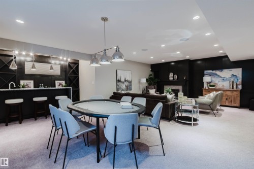 Spacious entertainment area featuring a wet bar with a light-colored countertop and built-in wine storage - 3435 Keswick Boulevard, Edmonton, AB 