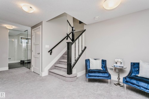 Carpeted staircase with dark wood newel post and railings - 3435 Keswick Boulevard, Edmonton, AB 